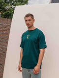 Muster des grünen, übergroßen Sante-T-Shirts